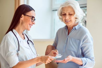 Smiling nurse providing her patient with medication